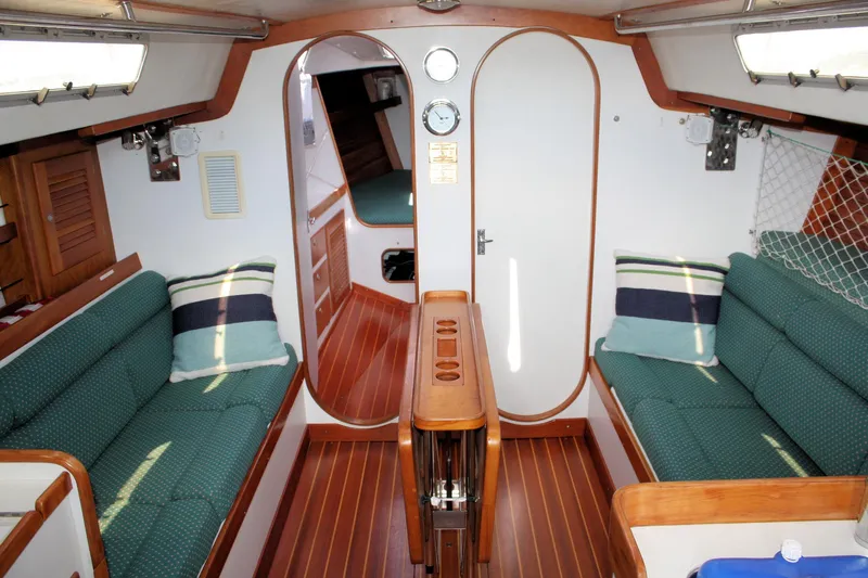 Lola Yacht Photos Pics Interior of 1995 J Boats J/130 sailboat with cozy seating and wooden finishes.