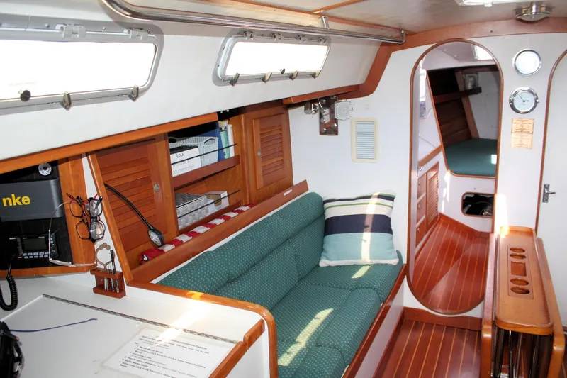 Lola Yacht Photos Pics Interior of 1995 J Boats J/130 sailboat with cozy seating and wooden accents.