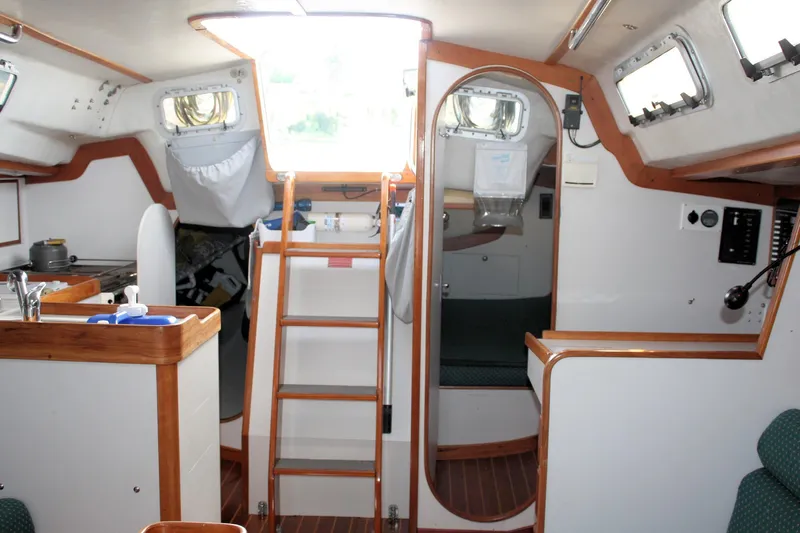 Lola Yacht Photos Pics Interior of 1995 J Boats J/130 sailboat, featuring a compact kitchen and cozy seating area.