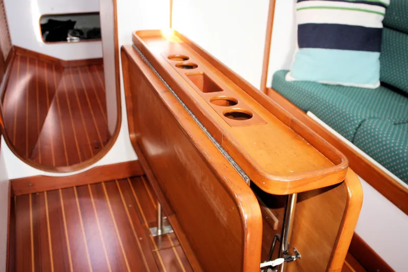 Lola Yacht Photos Pics Interior of 1995 J Boats J/130 sailboat with wooden table and seating.