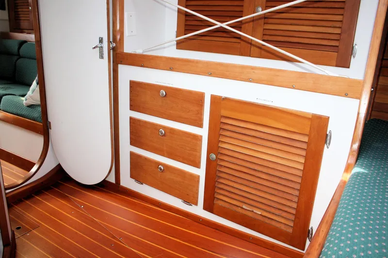 Lola Yacht Photos Pics Interior of 1995 J Boats J/130, featuring wooden cabinets and green seating.