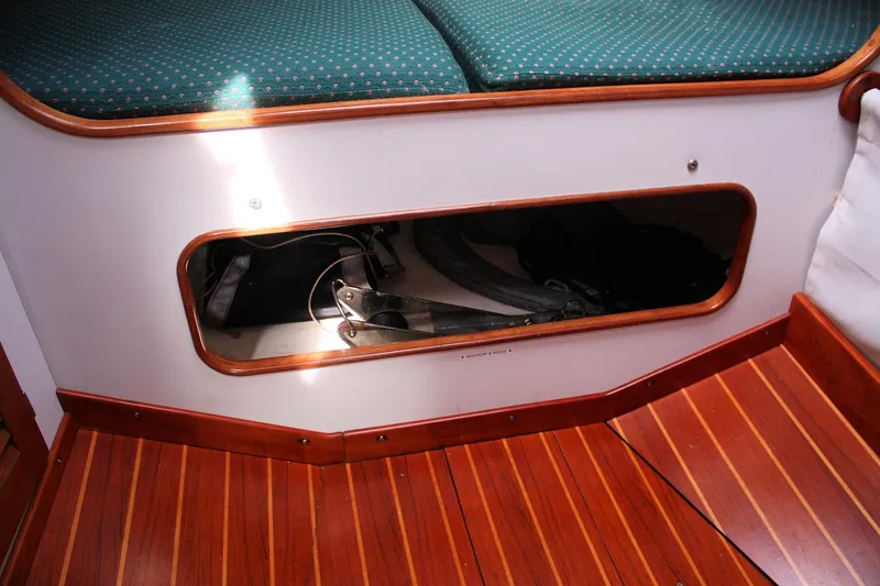 Lola Yacht Photos Pics Interior of 1995 J Boats J/130 showing storage compartment and wooden flooring.
