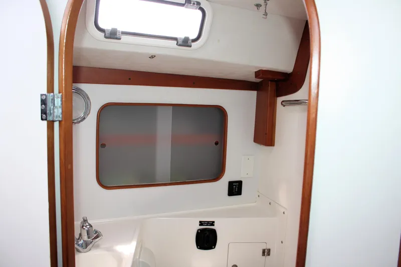 Lola Yacht Photos Pics Interior of 1995 J Boats J/130 sailboat bathroom with wooden trim and window.