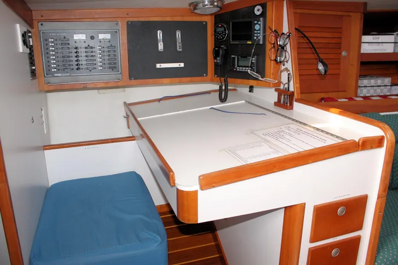 Lola Yacht Photos Pics Navigation station inside 1995 J Boats J/130 sailboat, featuring control panels and seating.