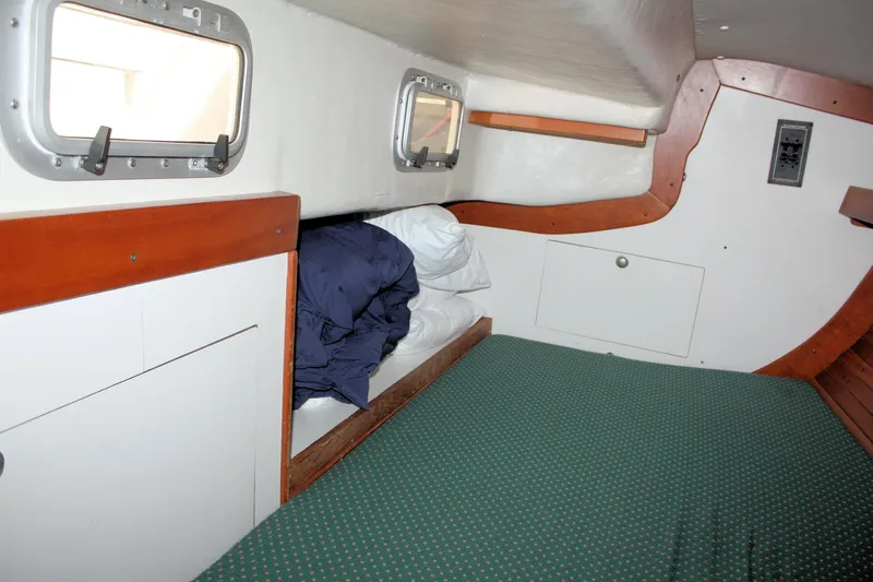 Lola Yacht Photos Pics Cozy cabin interior of 1995 J Boats J/130 sailboat with bedding and portholes.