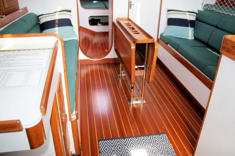 Lola Yacht Photos Pics Interior of 1995 J Boats J/130 sailboat with wooden flooring and green seating.