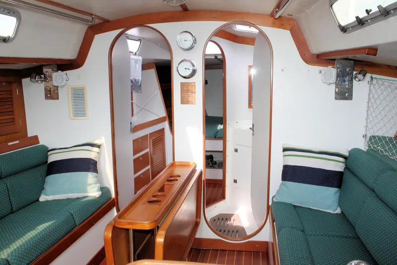 Lola Yacht Photos Pics Interior of 1995 J Boats J/130 sailboat with green seating and wooden accents.