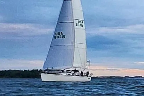 Lola Yacht Photos Pics Sailing yacht J Boats J/130, 1995 model, on open water at sunset.