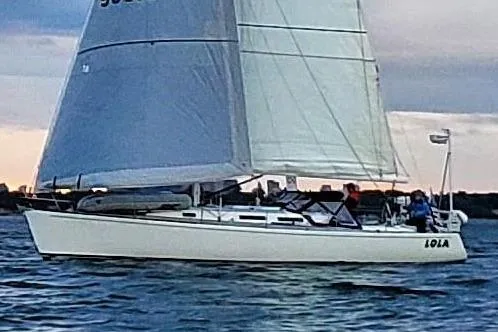 Lola Yacht Photos Pics Sailing yacht J Boats J/130, 1995 model, cruising on open water at sunset.