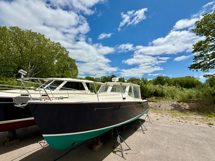 Reposado Yacht Photos Pics 2005 MJM 34z Downeast boat on land under a blue sky with clouds.