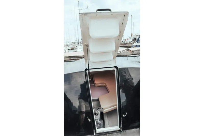  Yacht Photos Pics Open hatch of 2008 Fabio Buzzi FB 38 boat, revealing interior and docked marina background.