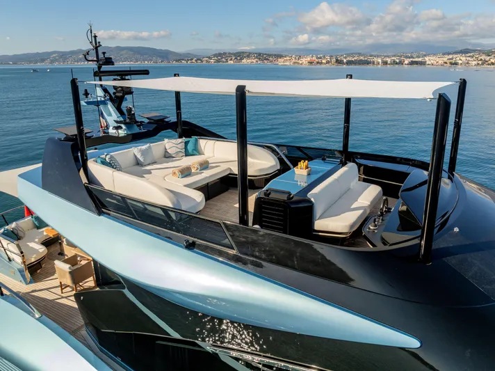Delfina Yacht Photos Pics Luxurious 2024 Mangusta 104 REV yacht with elegant deck seating and ocean view.