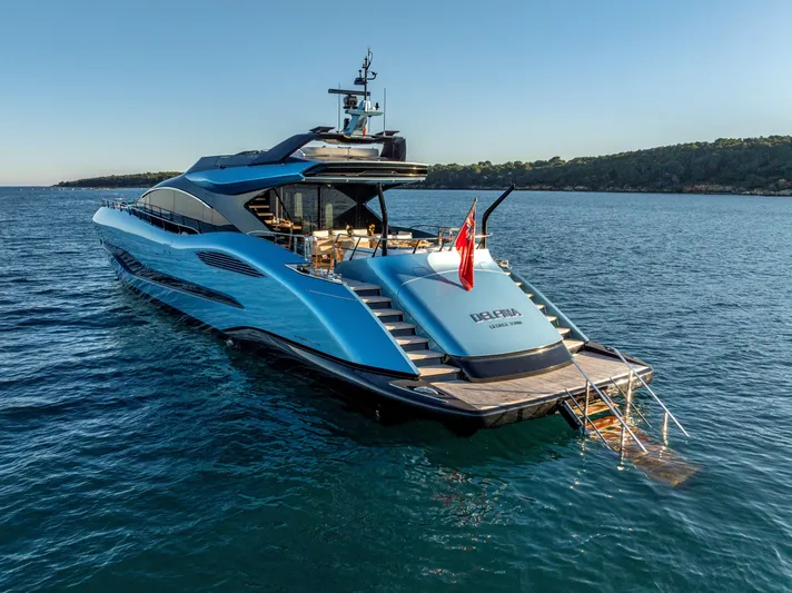 Delfina Yacht Photos Pics 2024 Mangusta 104 REV yacht on serene blue waters, showcasing sleek design and luxury features.