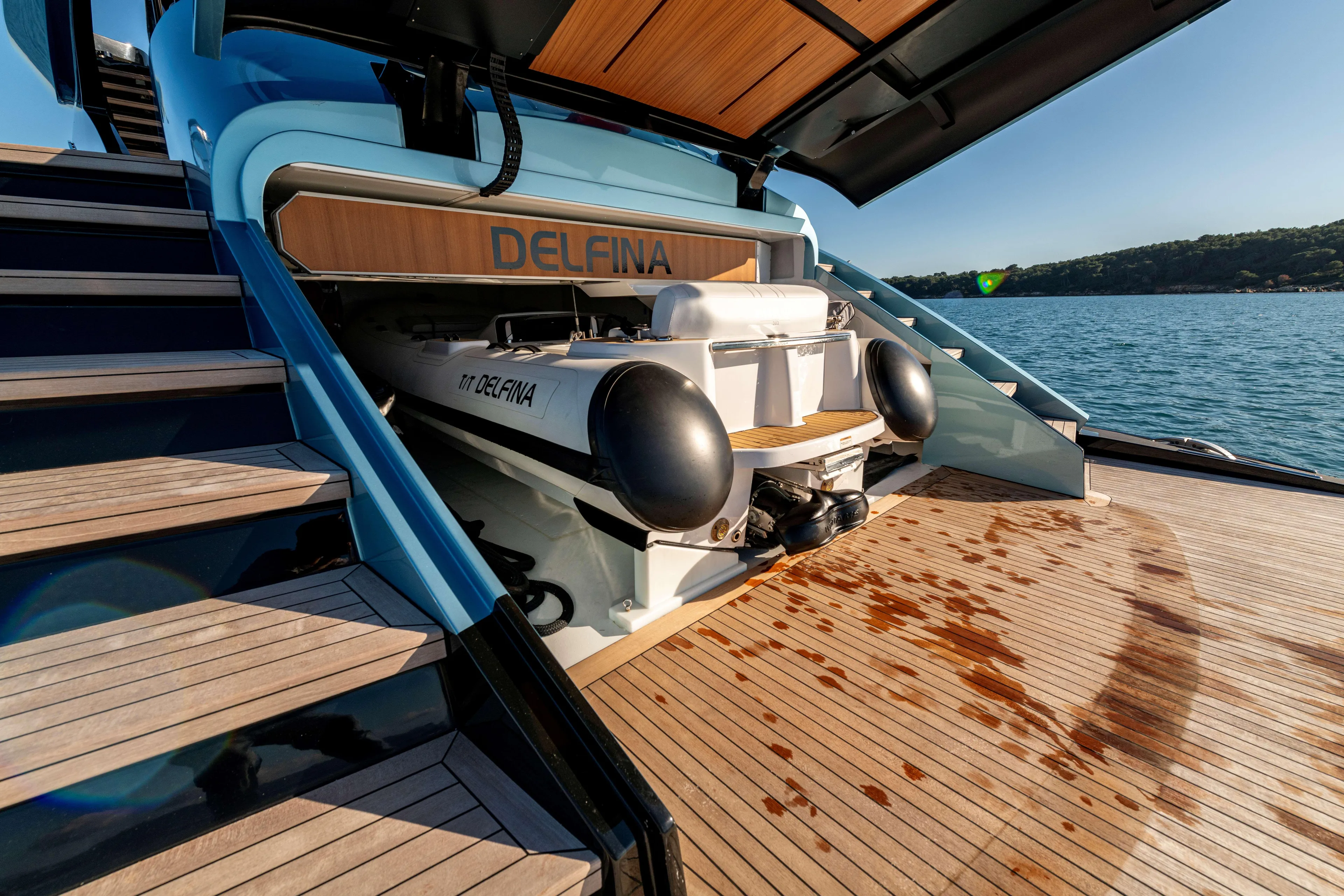 Delfina Yacht Photos Pics 2024 Mangusta 104 REV yacht with tender on deck, docked by the sea.