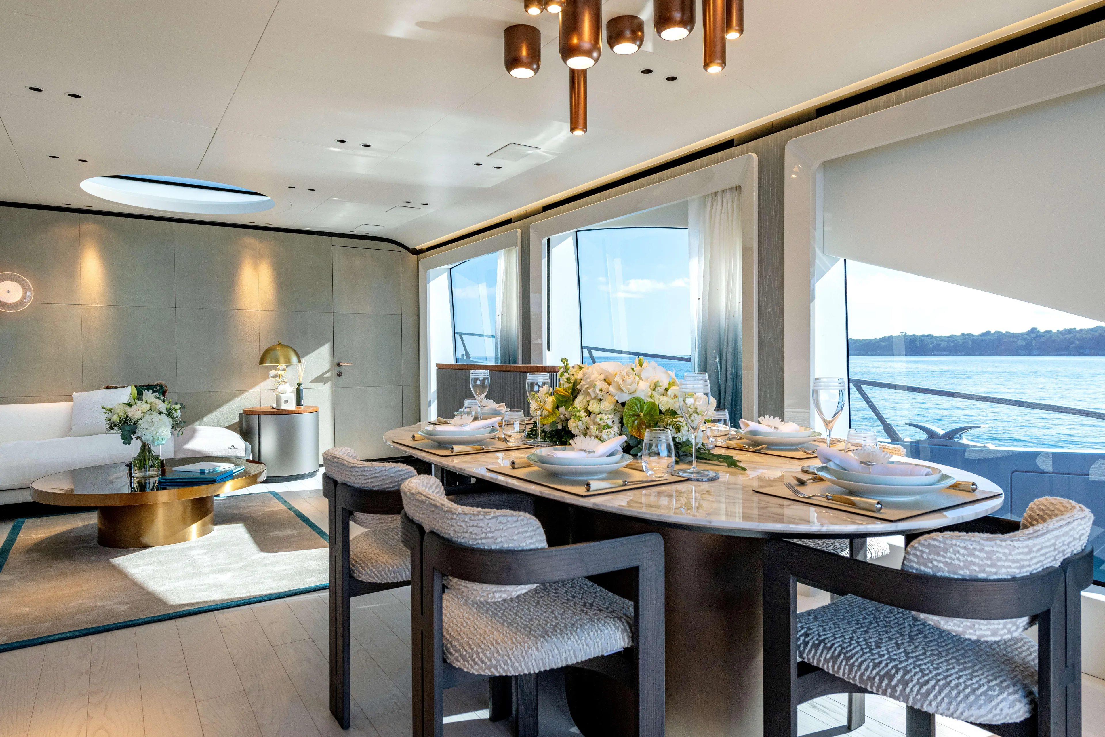Delfina Yacht Photos Pics Luxurious interior of 2024 Mangusta 104 REV yacht with elegant dining area and sea view.