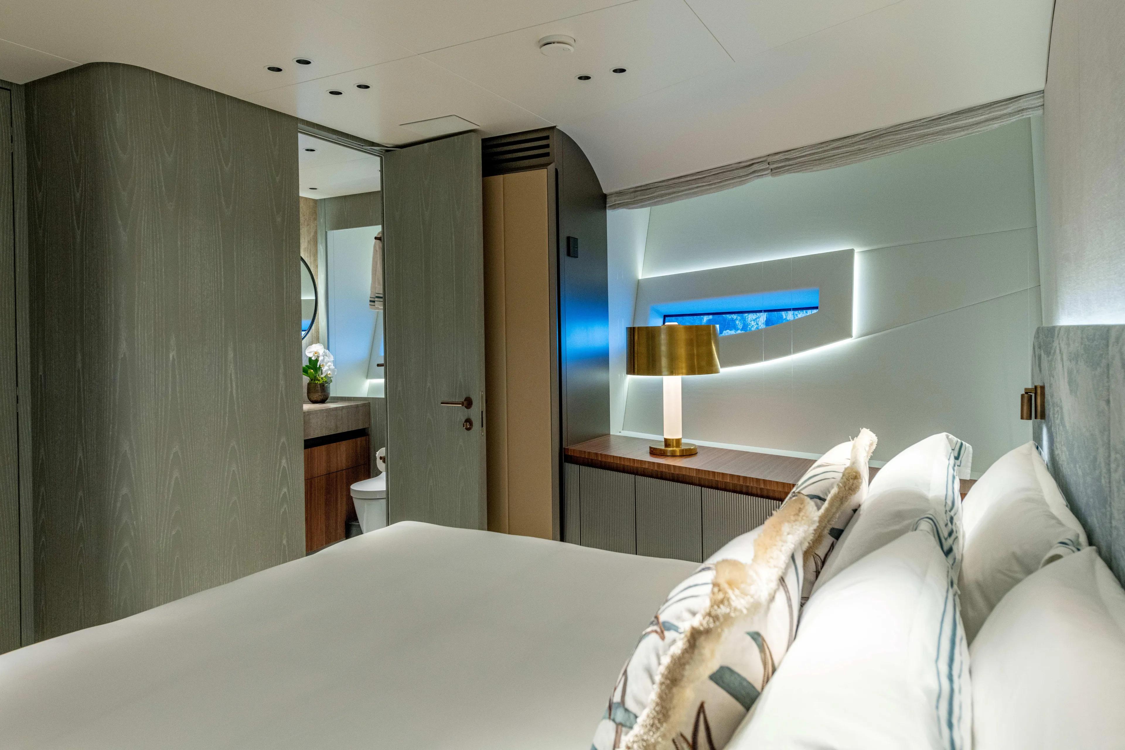 Delfina Yacht Photos Pics Luxurious bedroom interior of 2024 Mangusta 104 REV yacht, featuring modern design and elegant lighting.