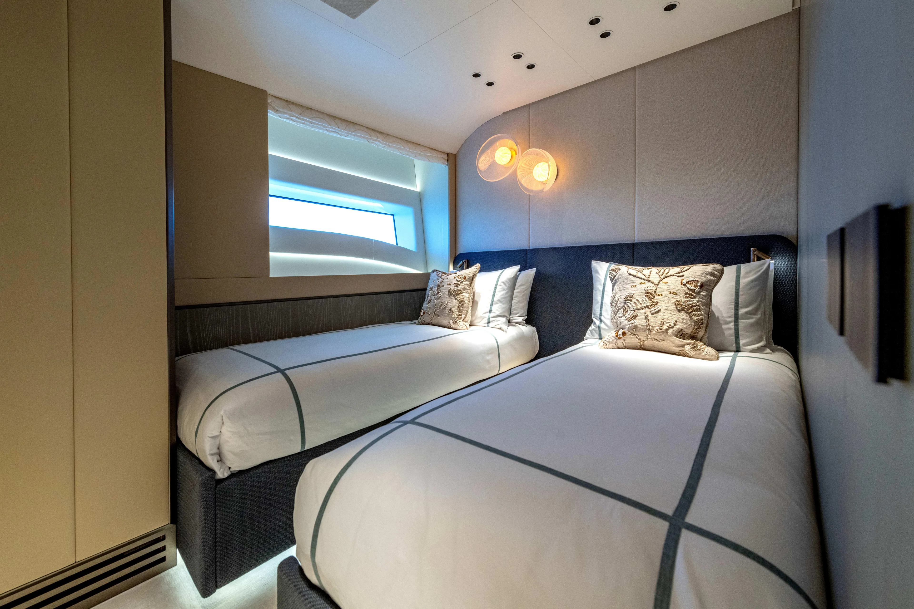 Delfina Yacht Photos Pics Luxurious twin bedroom in 2024 Mangusta 104 REV yacht, featuring modern design and ambient lighting.