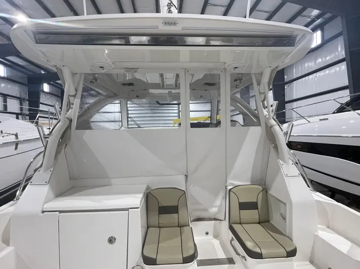 Sea Hawk Yacht Photos Pics 2020 Pursuit OS 355 Offshore boat interior with seating, displayed in a showroom.