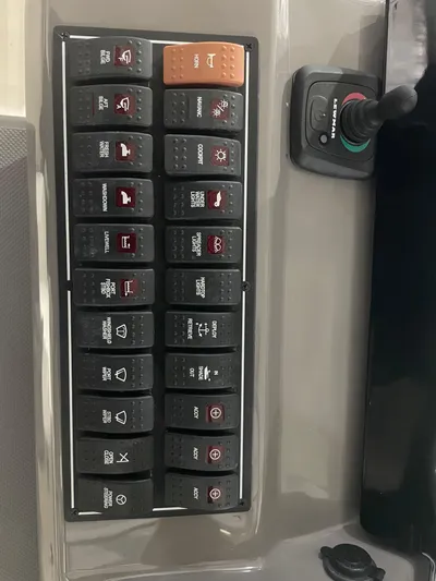 Sea Hawk Yacht Photos Pics Control panel of a 2020 Pursuit OS 355 Offshore boat with labeled switches.