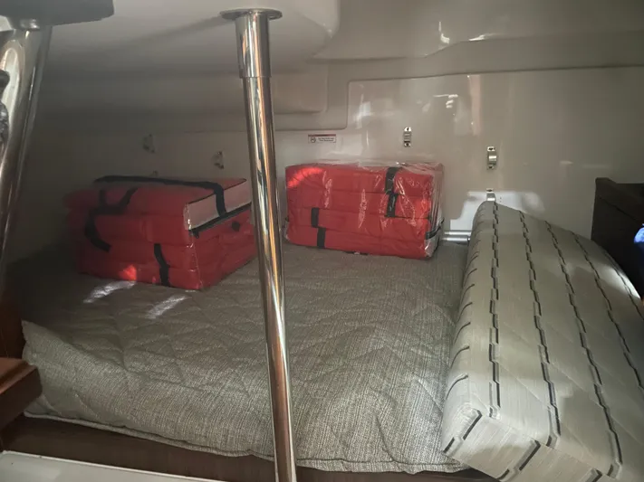 Sea Hawk Yacht Photos Pics 2020 Pursuit OS 355 Offshore cabin with red life jackets on a bed.