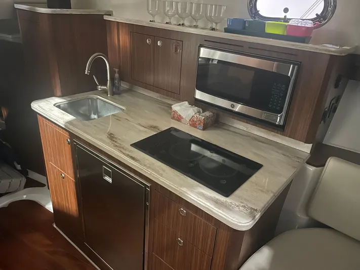 Sea Hawk Yacht Photos Pics 2020 Pursuit OS 355 Offshore yacht kitchen with sink, stove, and microwave.