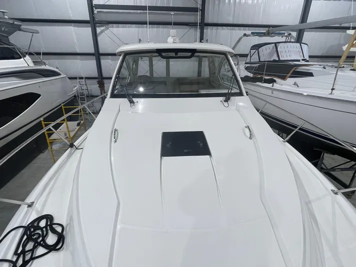 Sea Hawk Yacht Photos Pics 2020 Pursuit OS 355 Offshore boat in indoor storage, showcasing sleek design and spacious deck.