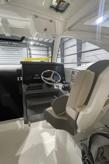 Sea Hawk Yacht Photos Pics 2020 Pursuit OS 355 Offshore boat cockpit with steering wheel and control panel.