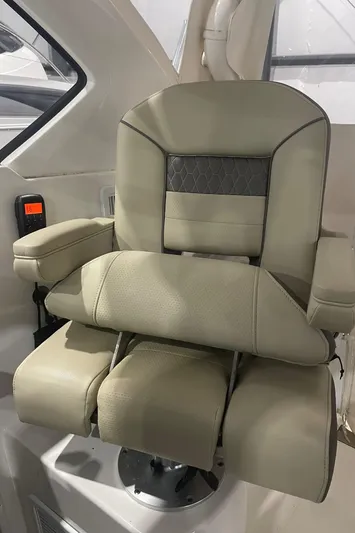 Sea Hawk Yacht Photos Pics Luxurious captain's chair in 2020 Pursuit OS 355 Offshore boat, featuring plush beige upholstery.