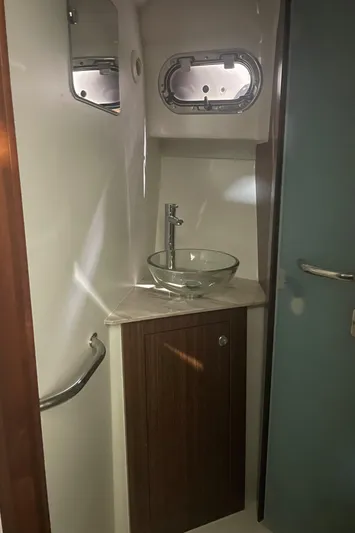 Sea Hawk Yacht Photos Pics 2020 Pursuit OS 355 Offshore bathroom with glass sink and porthole window.