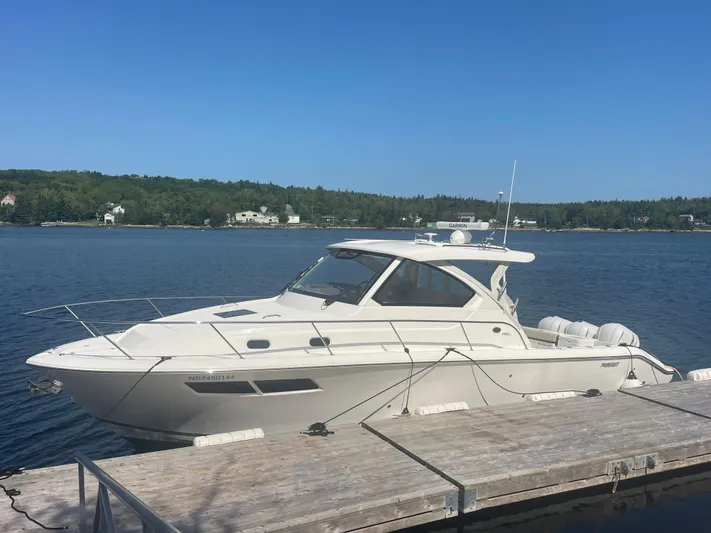 Sea Hawk Yacht Photos Pics 2020 Pursuit OS 355 Offshore boat docked on a serene lake under clear blue skies.