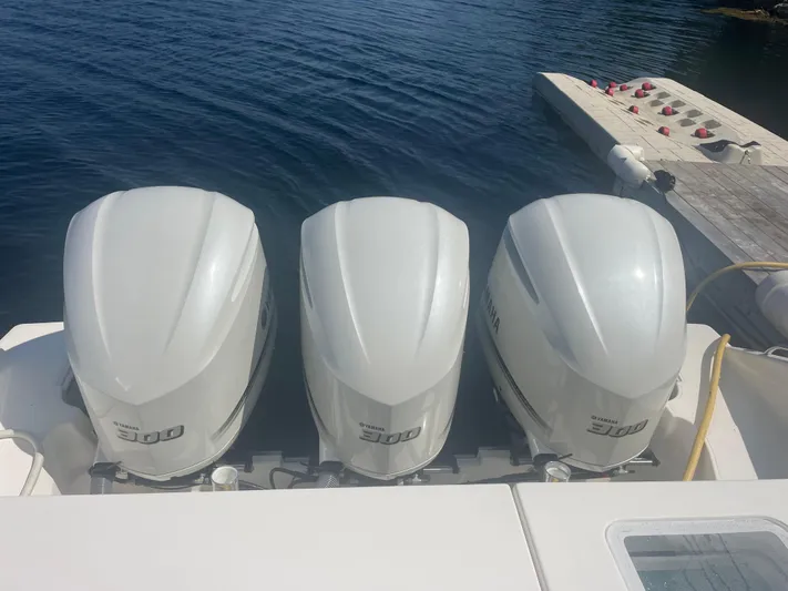 Sea Hawk Yacht Photos Pics Triple Yamaha 300 engines on a 2020 Pursuit OS 355 Offshore boat, docked by the water.