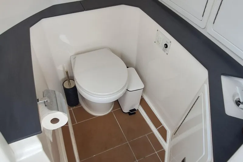  Yacht Photos Pics 2021 Aviara AV32 OB boat bathroom with toilet, sink, and storage cabinets.
