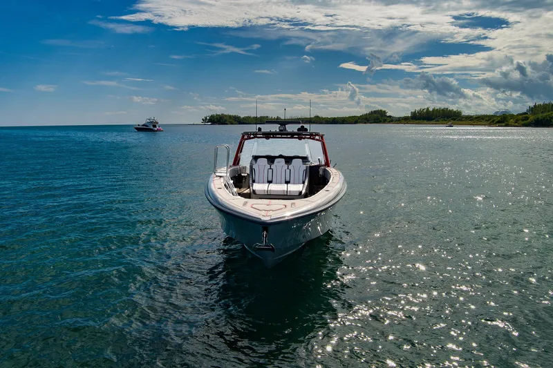  Yacht Photos Pics 2023 Midnight Express 43 Open boat on serene water under a partly cloudy sky.