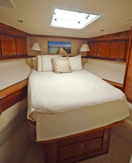 Gabby Millan 2 Yacht Photos Pics Luxurious bedroom in a 2003 Bertram 67 Convertible yacht with skylight and wooden cabinets.