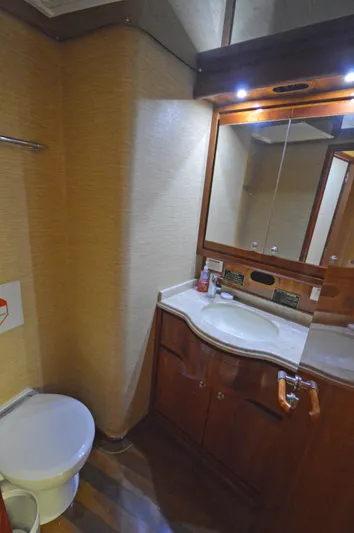 Gabby Millan 2 Yacht Photos Pics 2003 Bertram 67 Convertible yacht bathroom with wooden cabinetry and modern fixtures.