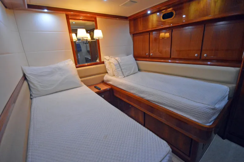 Gabby Millan 2 Yacht Photos Pics 2003 Bertram 67 Convertible yacht cabin with twin beds and wooden cabinetry.