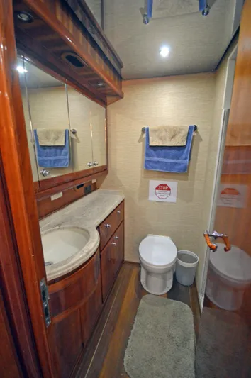 Gabby Millan 2 Yacht Photos Pics 2003 Bertram 67 Convertible yacht bathroom with wooden cabinetry and modern fixtures.