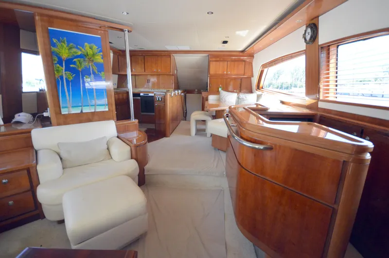 Gabby Millan 2 Yacht Photos Pics Luxurious interior of a 2003 Bertram 67 Convertible yacht with wooden finishes and comfortable seating.