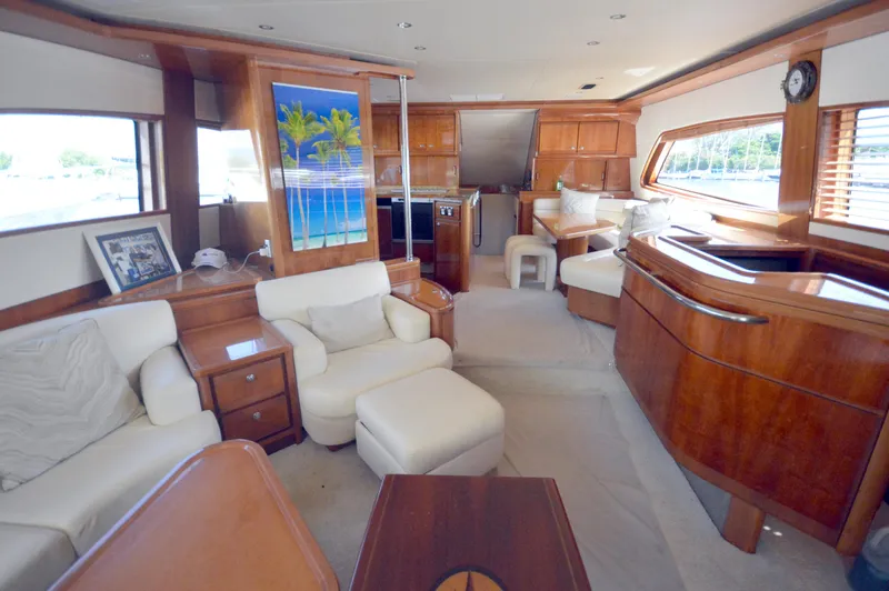 Gabby Millan 2 Yacht Photos Pics Luxurious interior of a 2003 Bertram 67 Convertible yacht with plush seating and wooden finishes.