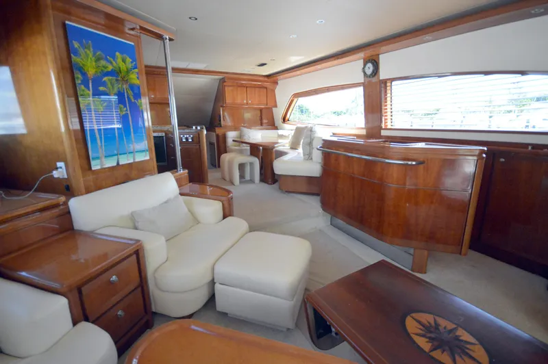 Gabby Millan 2 Yacht Photos Pics Luxurious interior of a 2003 Bertram 67 Convertible yacht with wooden furnishings and white seating.