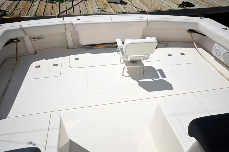 Gabby Millan 2 Yacht Photos Pics Bertram 67 Convertible 2003 boat deck with fishing chair and dock in background.