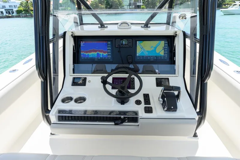  Yacht Photos Pics 2023 SeaVee 370Z boat console with dual screens and steering wheel on calm water.