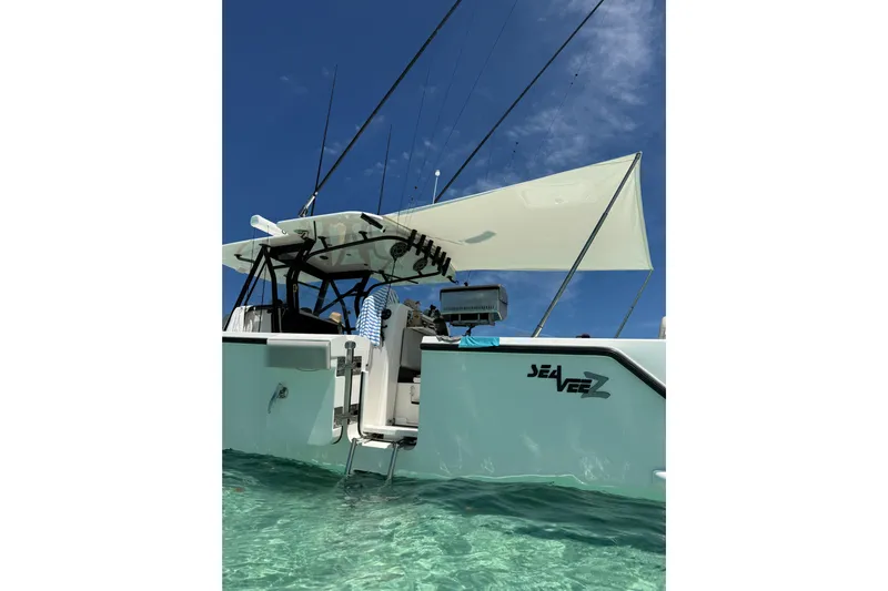  Yacht Photos Pics 2023 SeaVee 370Z boat in clear water, featuring fishing rods and canopy.