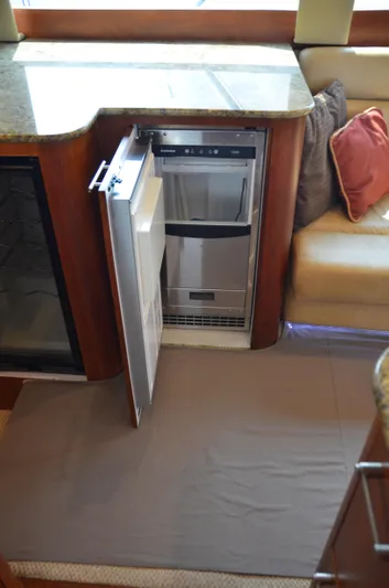 Cuda Yacht Photos Pics Open dishwasher in 2001 Buddy Davis 61 yacht interior, featuring granite countertop and cozy seating.