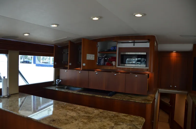 Cuda Yacht Photos Pics Luxurious kitchen interior of 2001 Buddy Davis 61 yacht with wooden cabinets and marble countertops.