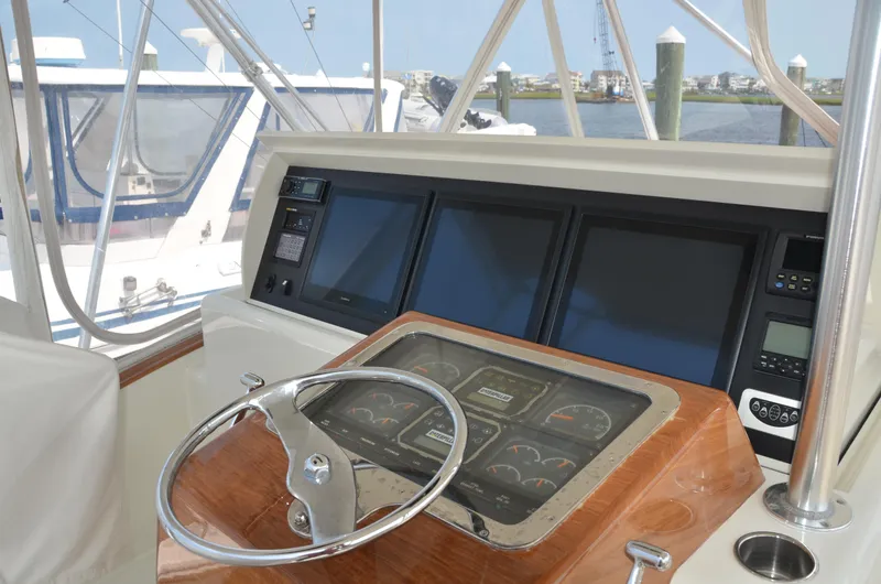 Cuda Yacht Photos Pics Helm of 2001 Buddy Davis 61 yacht with steering wheel and navigation screens.