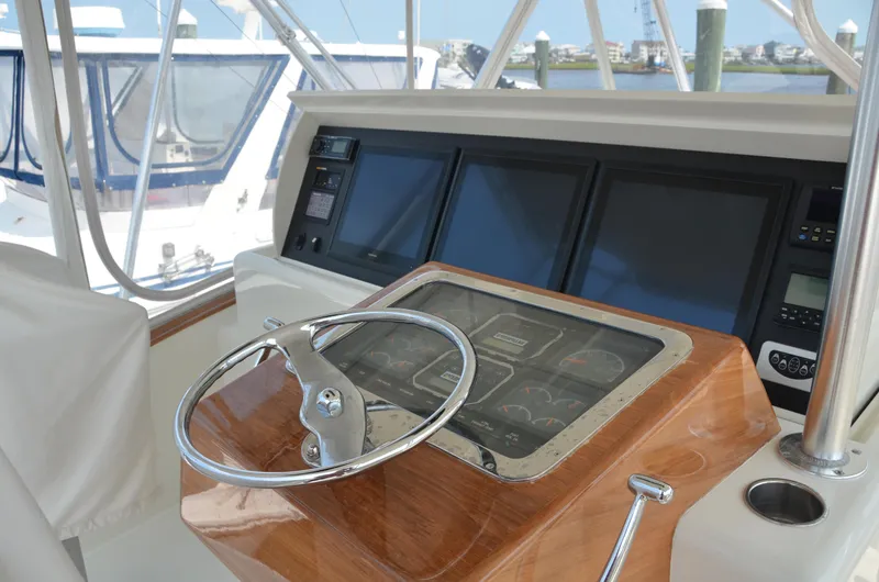 Cuda Yacht Photos Pics Helm of 2001 Buddy Davis 61 yacht with wooden console and modern navigation screens.