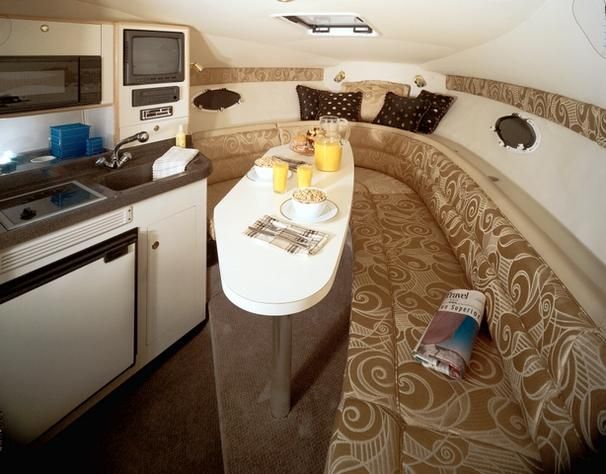 Interior of 2001 Larson Cabrio 270 boat with kitchenette and cozy seating area.