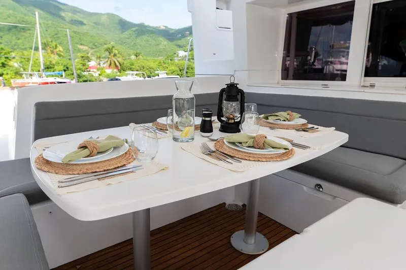Miss Summer Yacht Photos Pics Dining setup on Lagoon 450 yacht, 2014 model, with scenic mountain view.