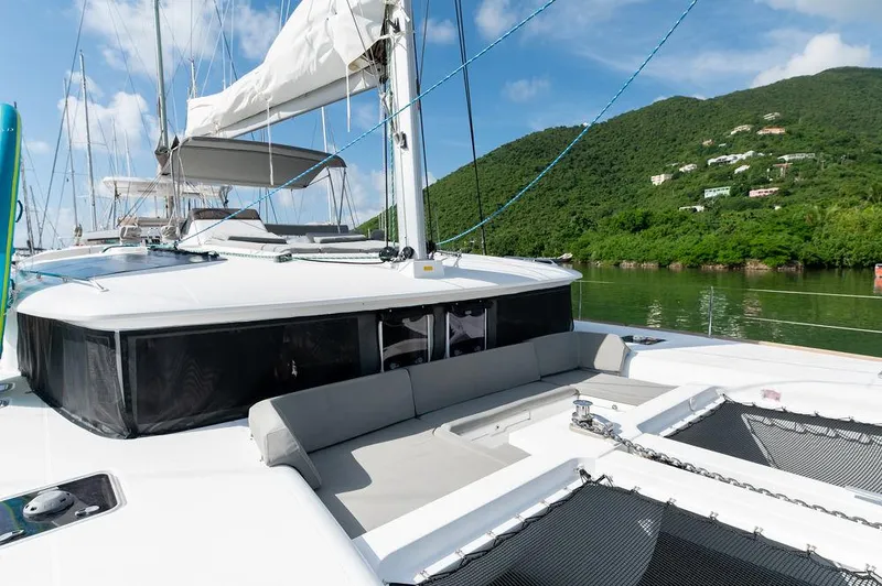 Miss Summer Yacht Photos Pics Lagoon 450 catamaran, 2014 model, docked near lush green hills under a clear blue sky.